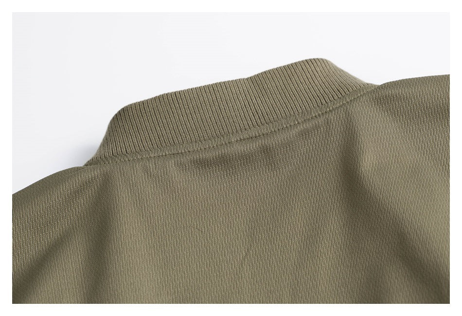 Close-up of the olive jacket's ribbed stand collar and upper fabric.