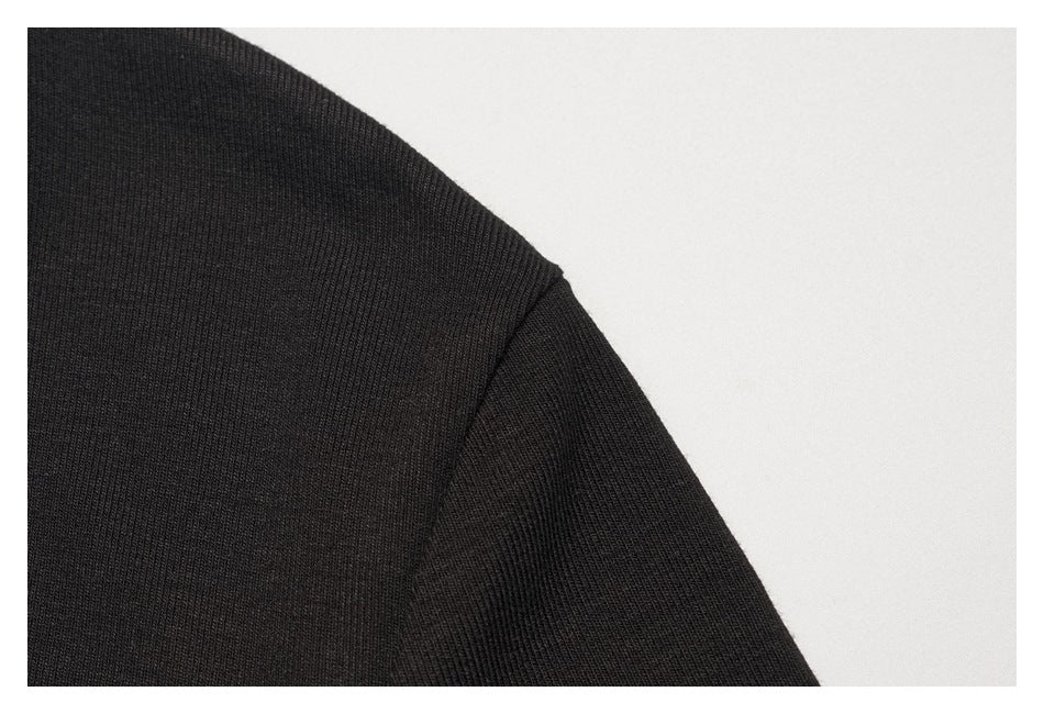 Close-up of the black shirt's shoulder seam and sleeve.