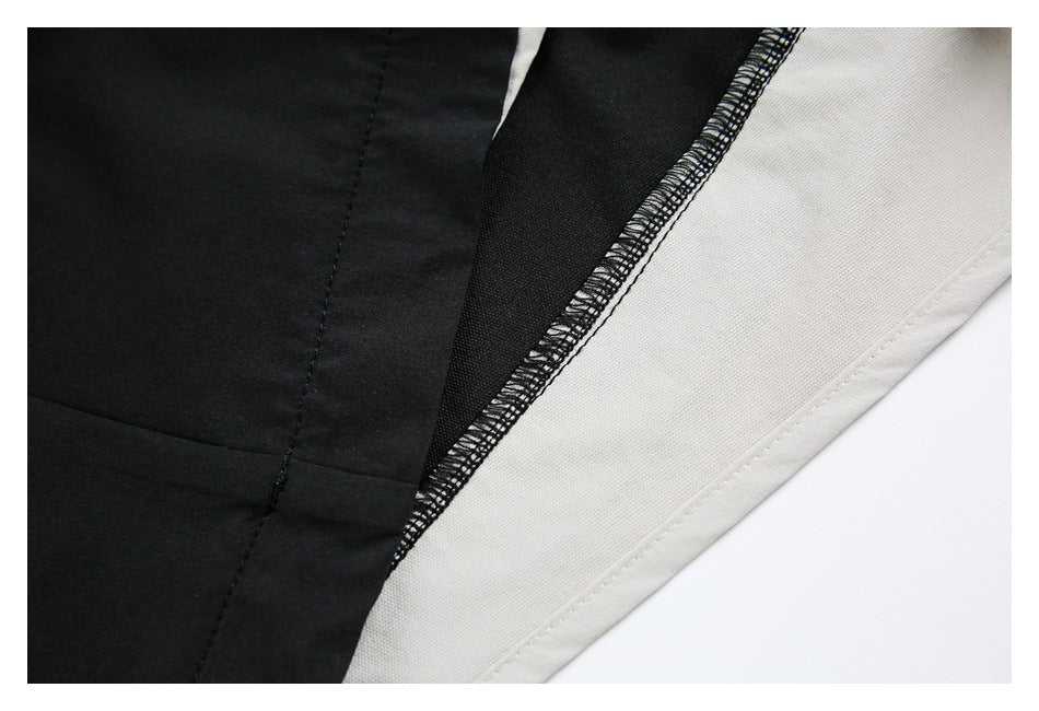 Close-up of black and cream trouser panels with visible overlocked seam finishing.