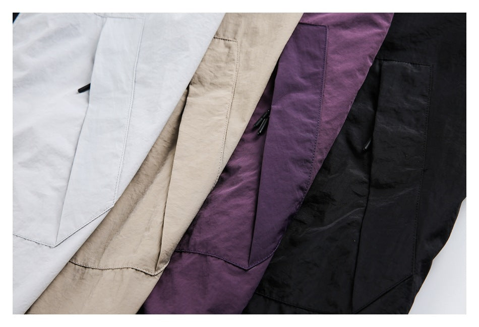 Close-up of large rectangular pockets on light gray, beige, purple, and black jackets.