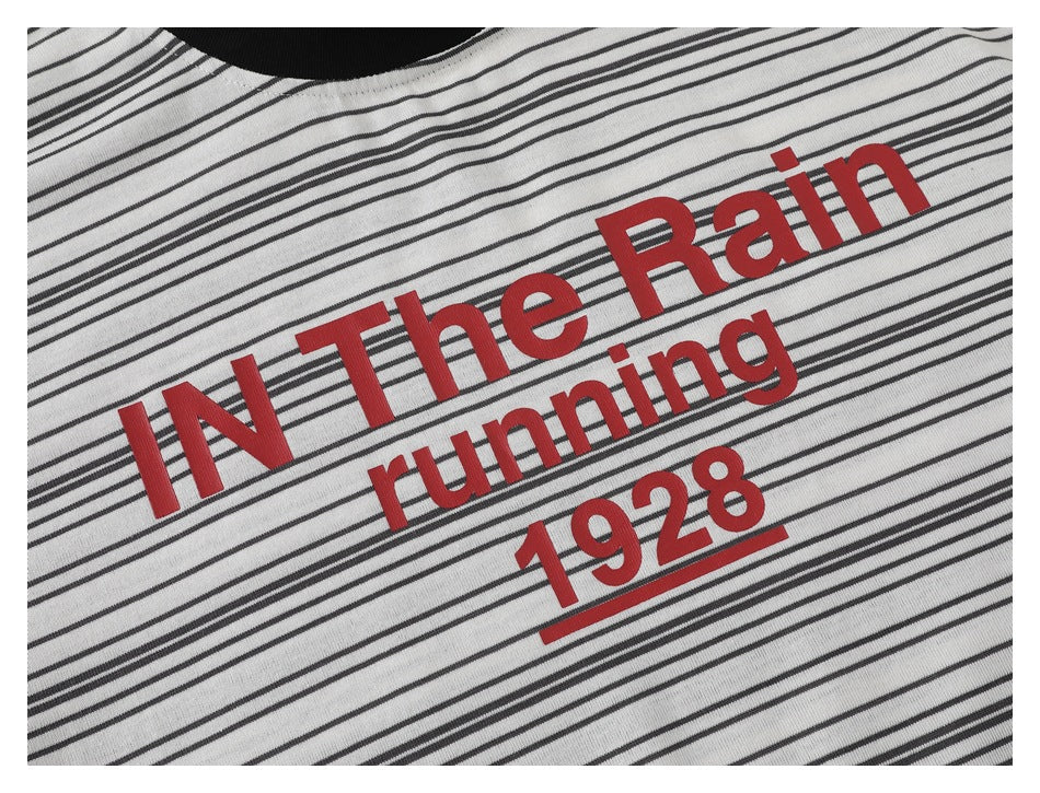 Close-up of the striped T-shirt's red chest print reading “IN The Rain running 1928.”