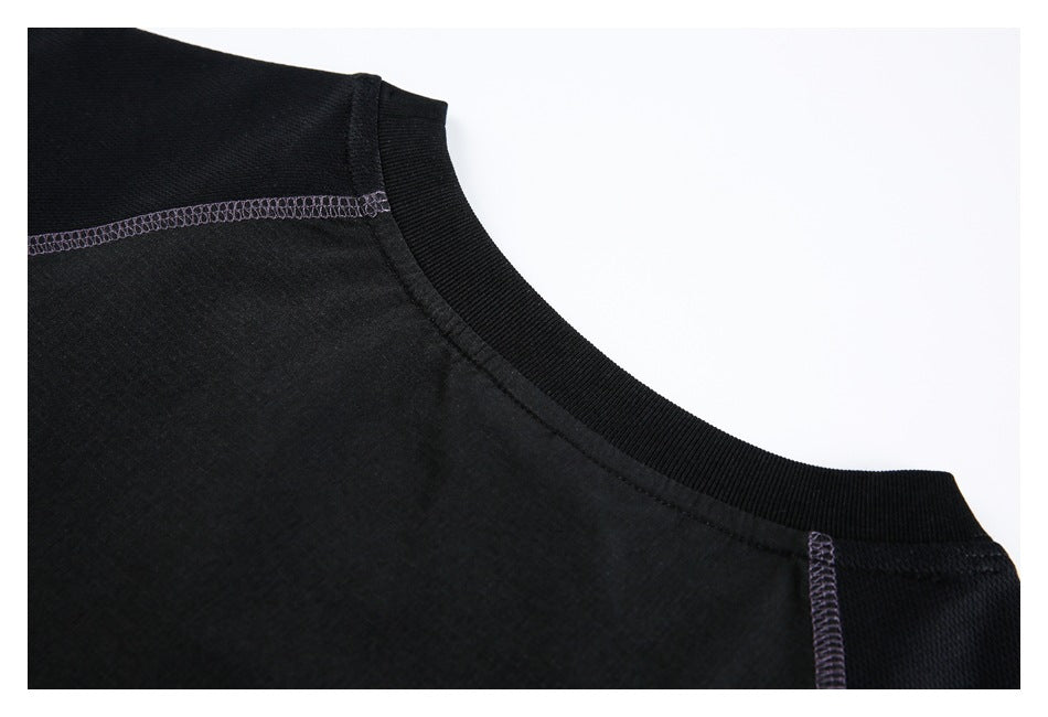 Close-up of a black ribbed crew neckline with pale purple seam stitching at the shoulders.