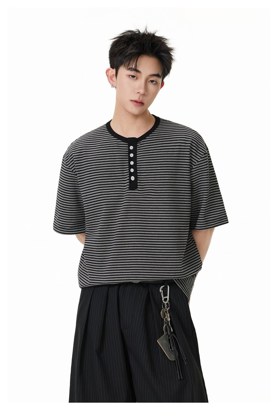 Model wearing a black and gray striped short-sleeve henley with a black placket and light buttons.