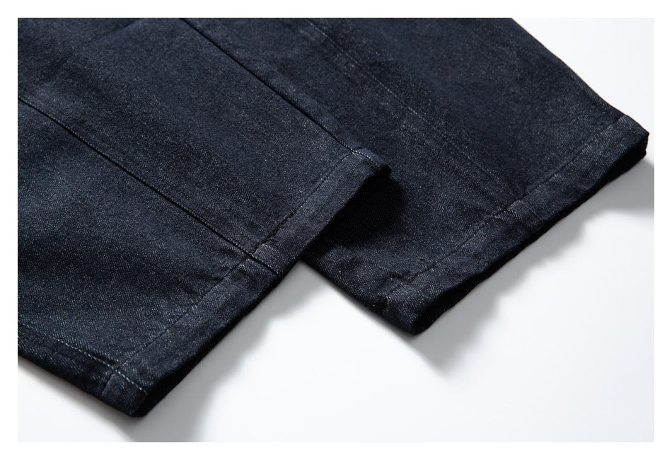 Close-up of dark indigo pant legs showing stitched hems.