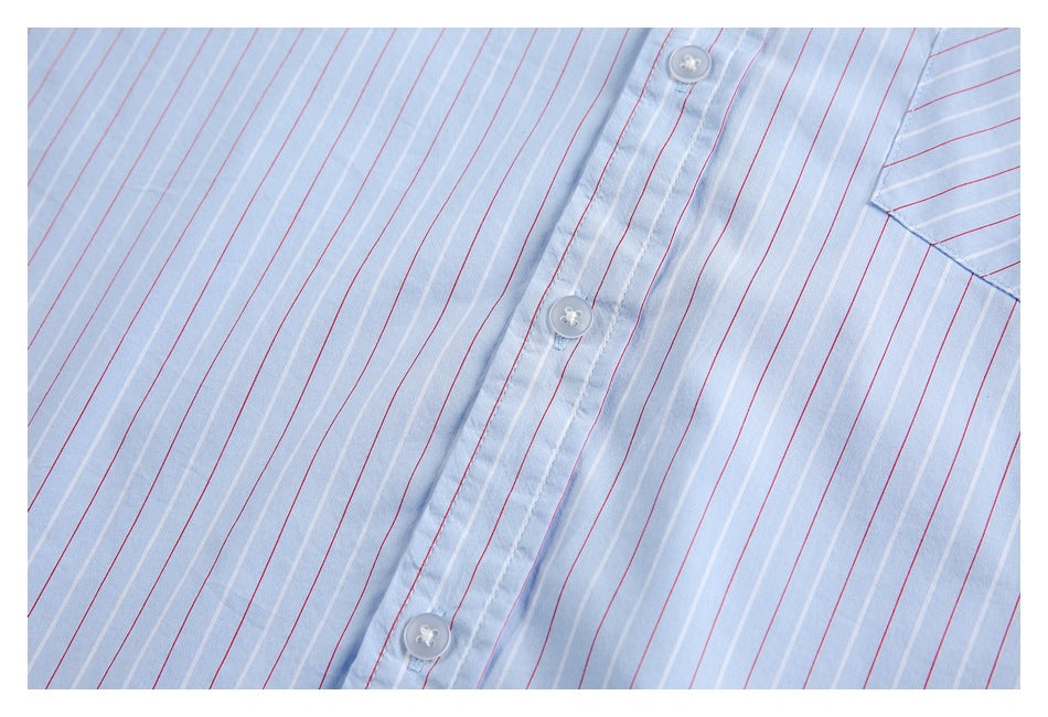 Close-up of the light blue shirt's button placket with red and white vertical stripes and white buttons.