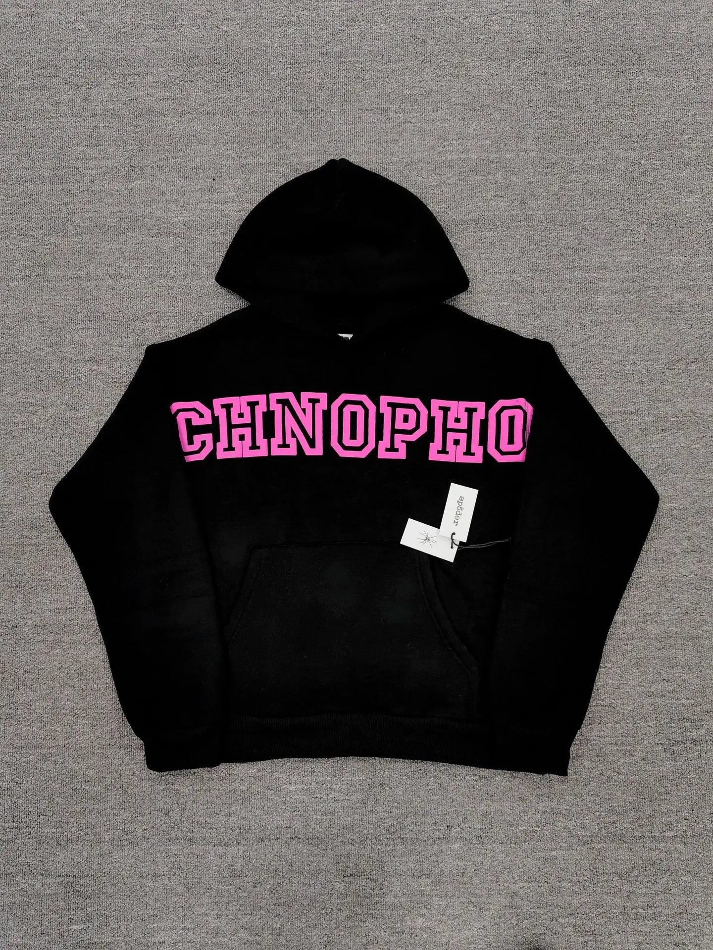 Sp5der black pullover hoodie with bold pink varsity graphic lettering on chest and kangaroo pocket