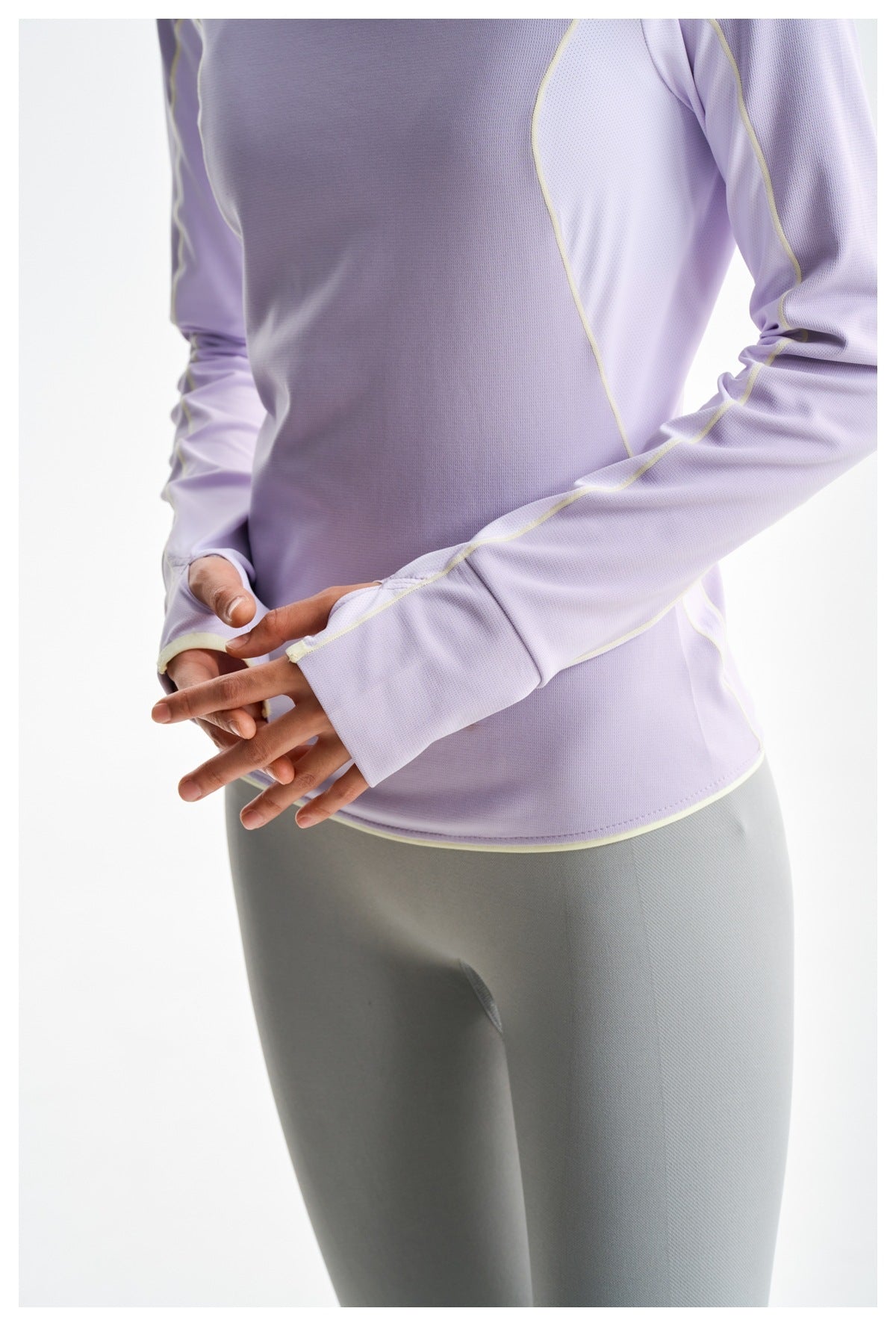 Close-up of the lavender top's long sleeves, thumbhole cuffs, pale contrast seams, and hem.