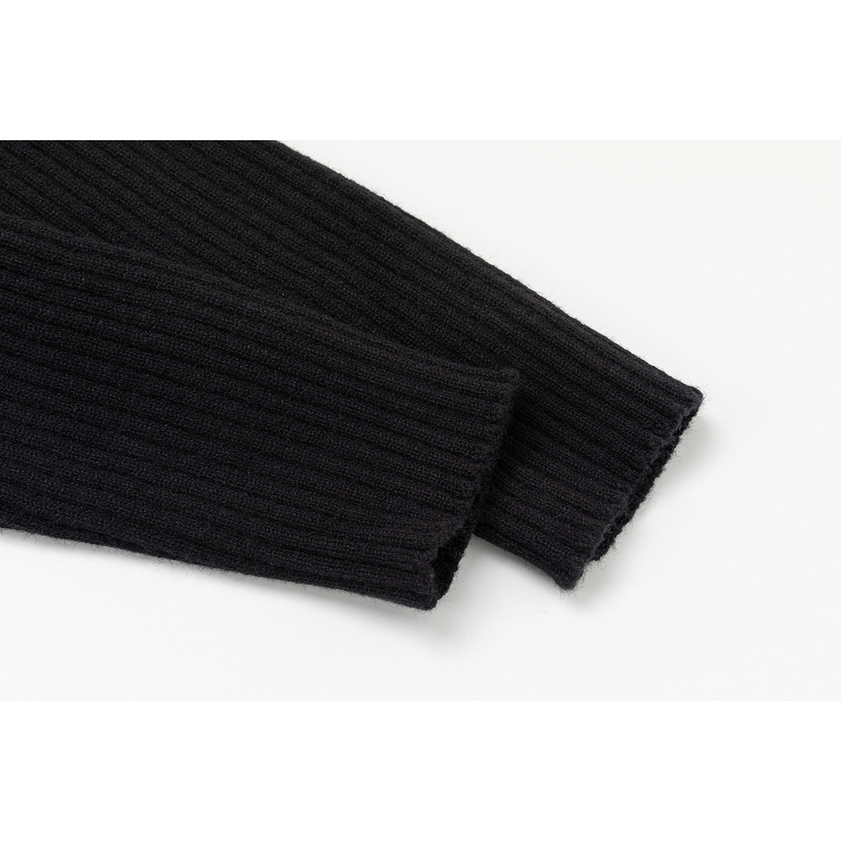 Close-up of the ribbed sleeve cuffs on a black knit cardigan.