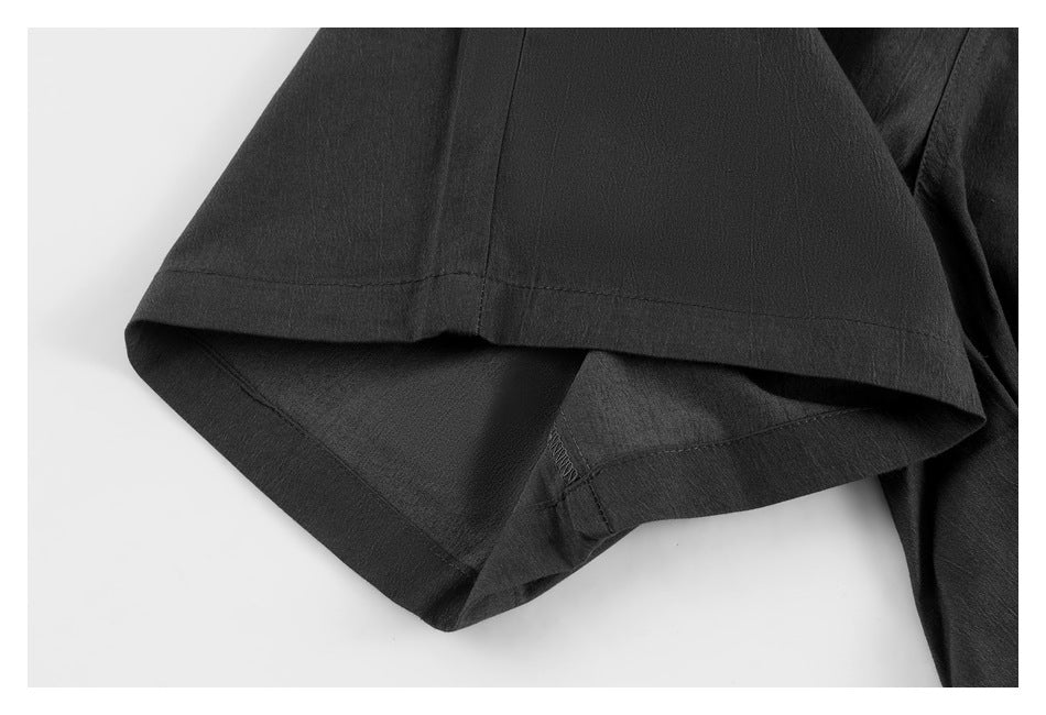 Close-up of a black trouser leg opening and stitched hem.