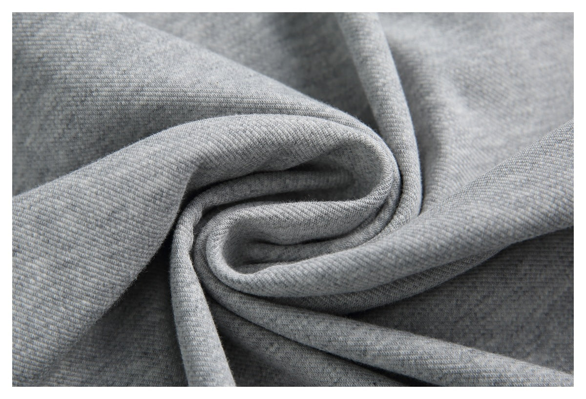 Close-up of gray knit fabric gathered into a swirl, showing its fine textured surface.