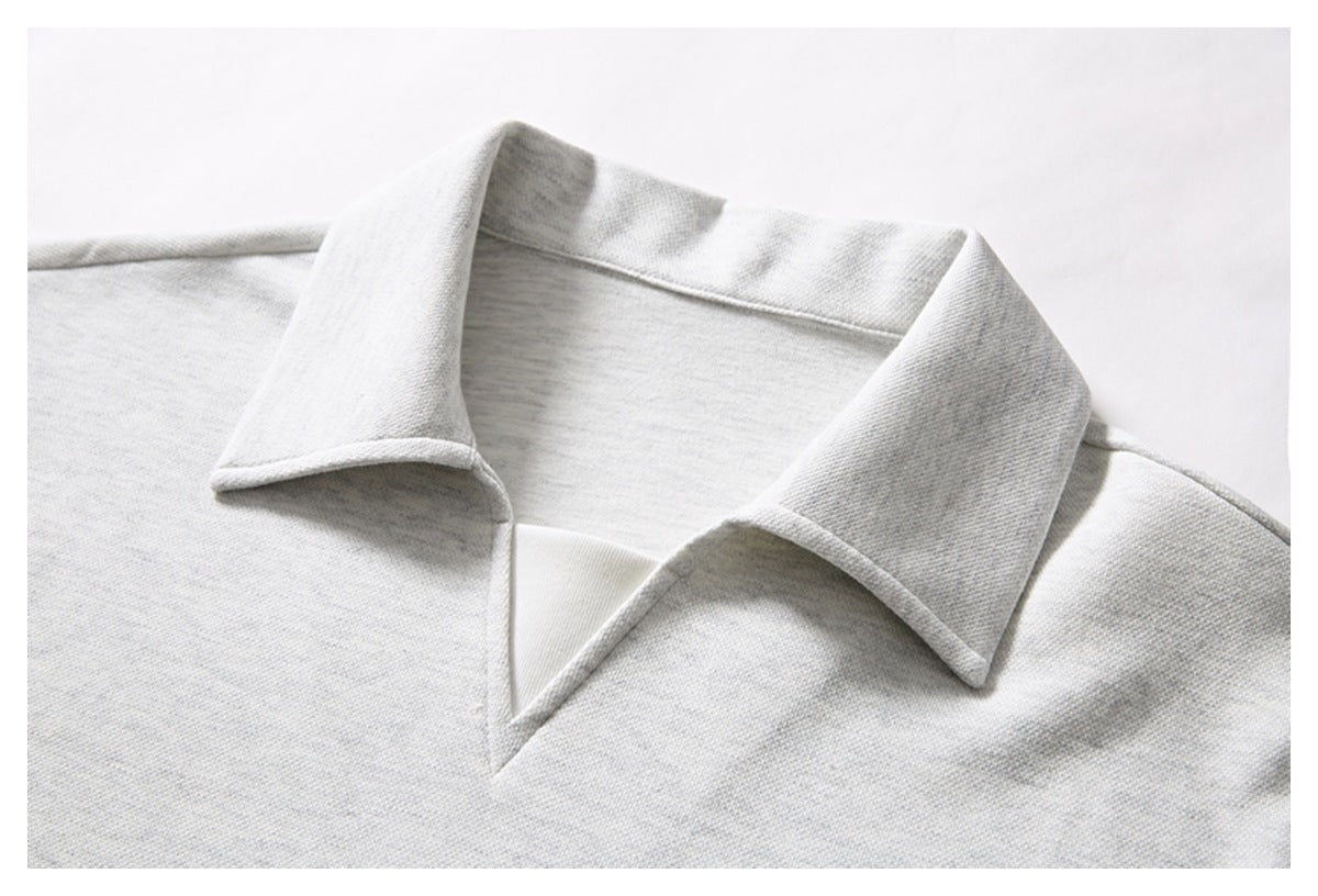 Close-up of a light gray polo shirt's wide pointed collar and open V-neck.