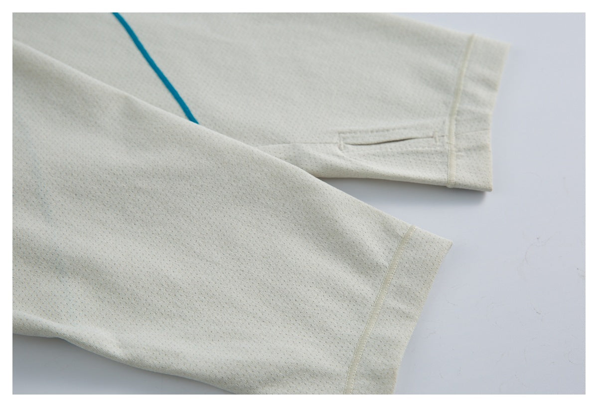 Close-up of the ivory top's long sleeve cuffs and teal seam detail.