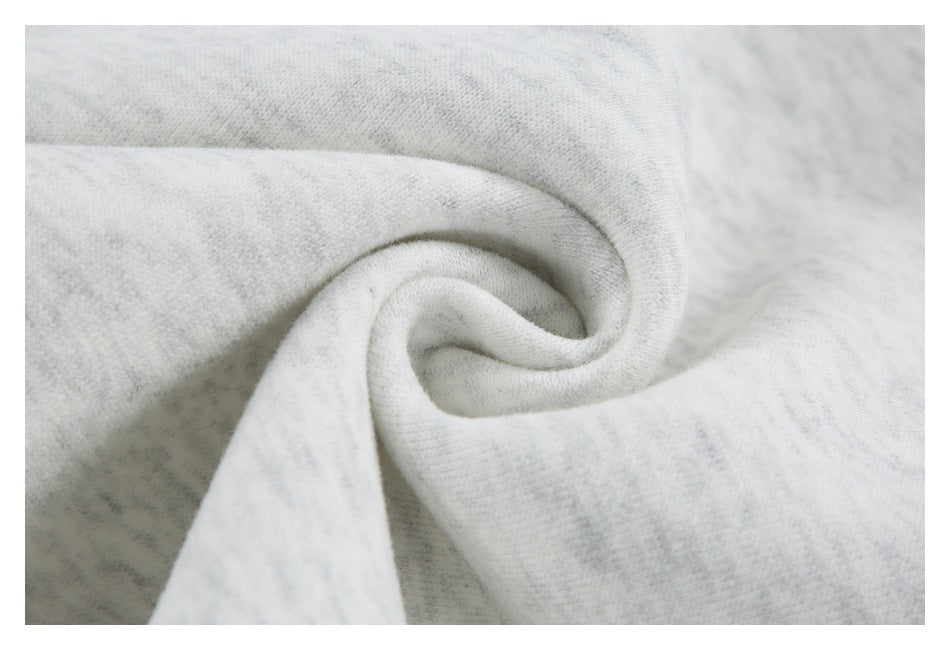 Close-up of light gray marl fabric gathered into a spiral fold, showing its surface texture.