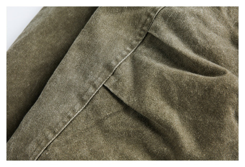 Close-up of olive-gray garment fabric with layered seam details.