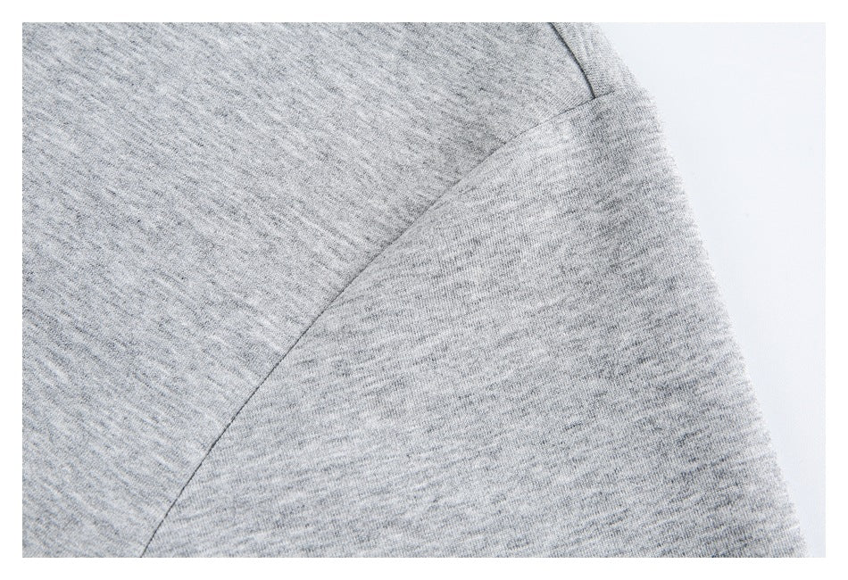 Close-up of the heather gray polo shirt sleeve and curved shoulder seam.