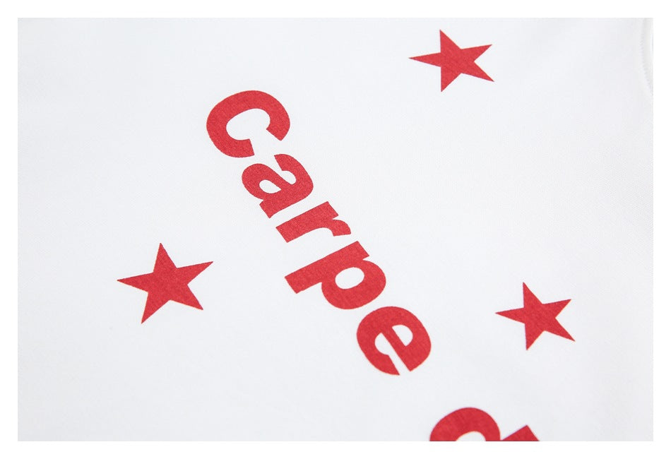 Close-up of red lettering and three red stars printed on white fabric.