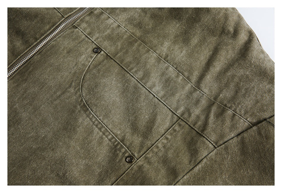 Close-up of a curved buttoned pocket and seam on an olive-brown jacket.