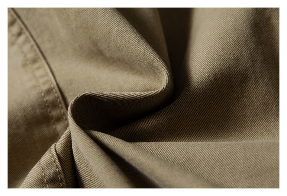 Close-up showing the khaki garment's twill texture, stitching, and folded fabric.