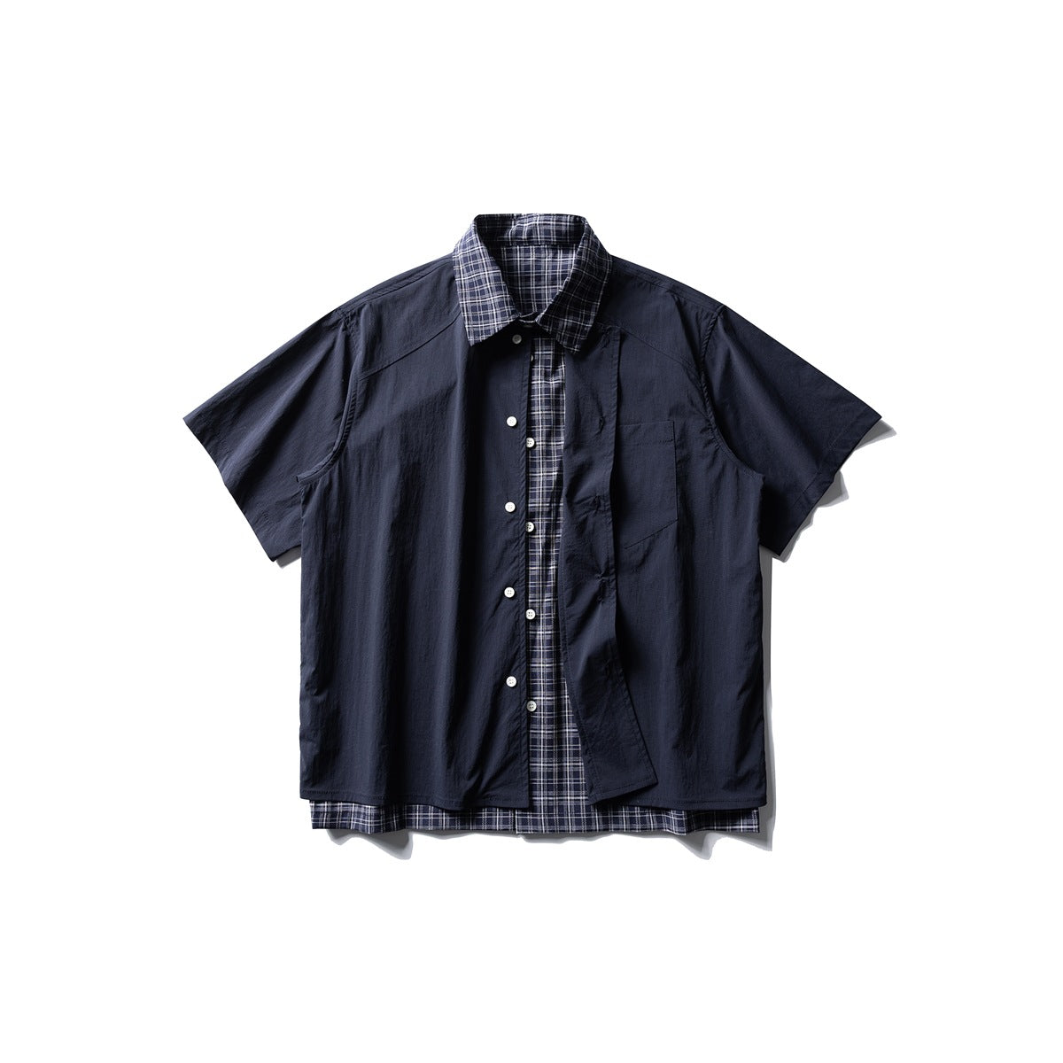 Navy short-sleeve button-up shirt with plaid collar and layered plaid hem, front flat lay with one placket panel angled open