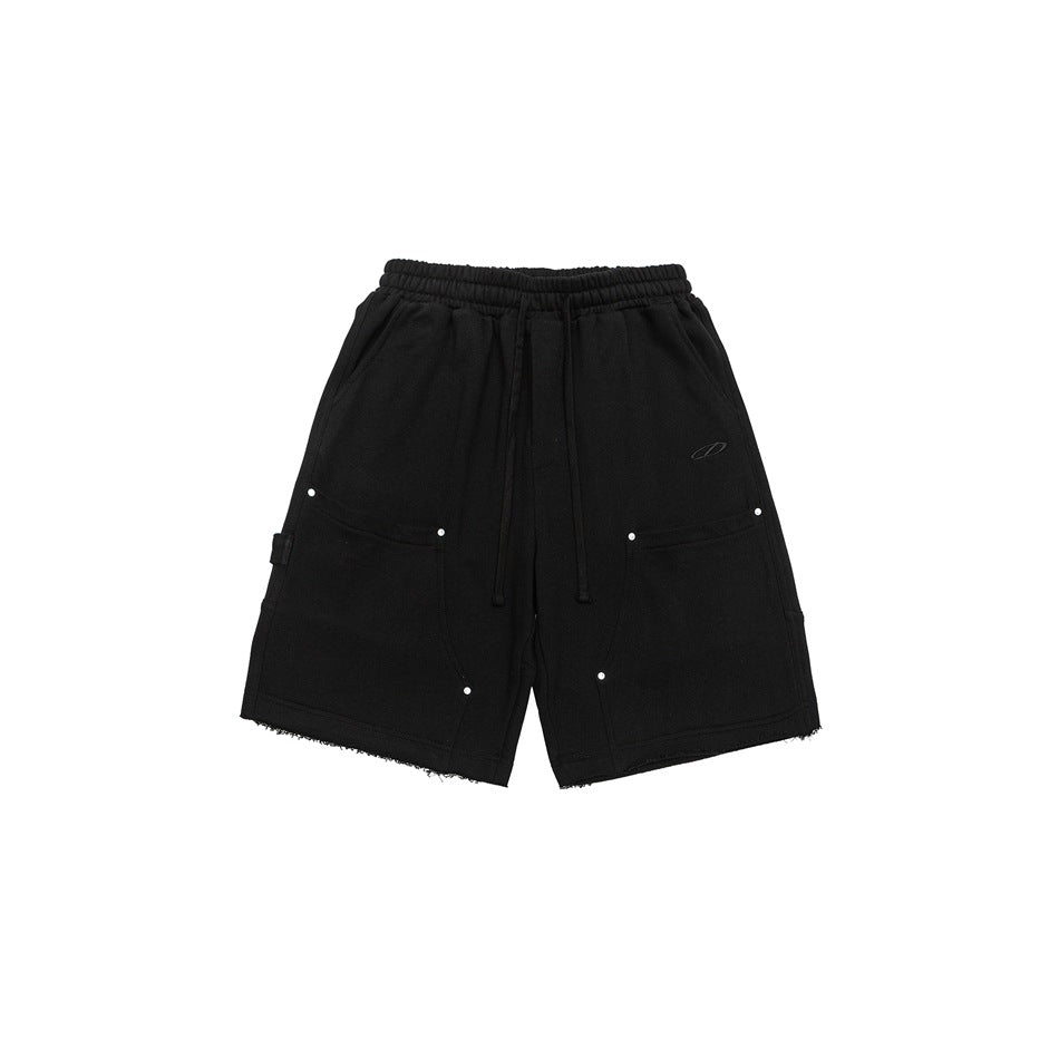 Black drawstring knee-length shorts with front patch pockets, metal rivets and raw hems, front view