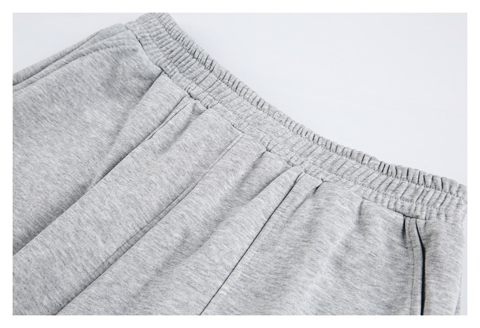Close-up of light gray heather sweatpants showing the elastic waistband and a nearby seam.