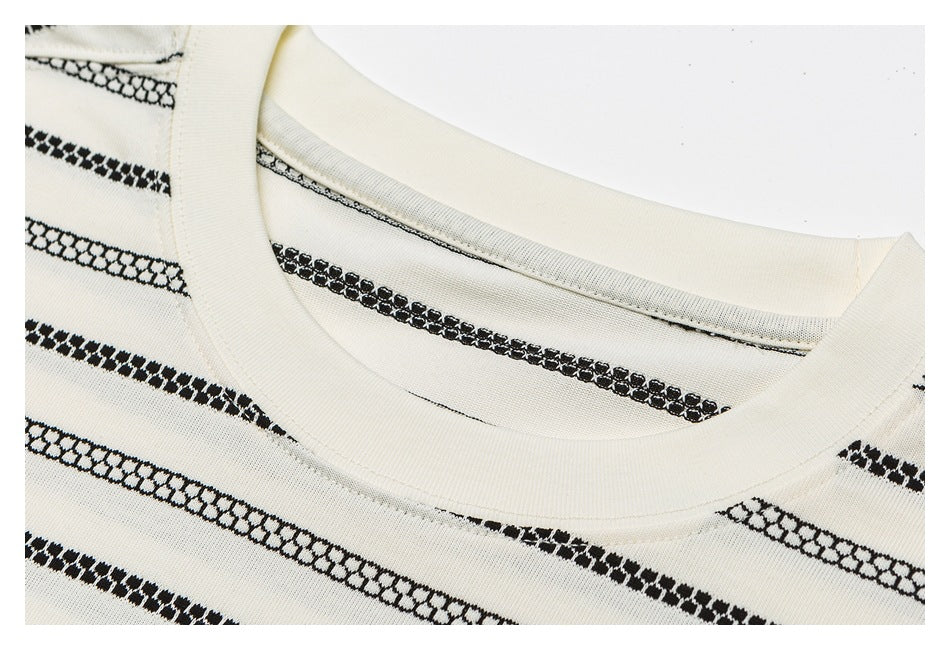 Close-up of an ivory crew neckline and black patterned horizontal stripes.
