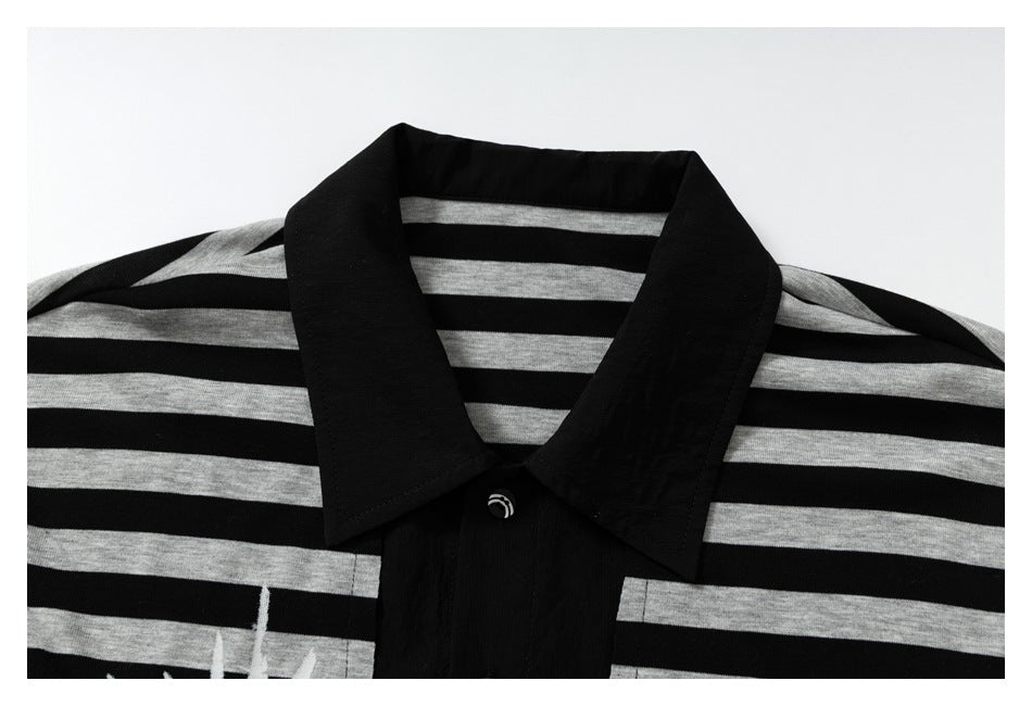 Close-up of the black collar, button placket, and gray stripes on a black polo shirt.