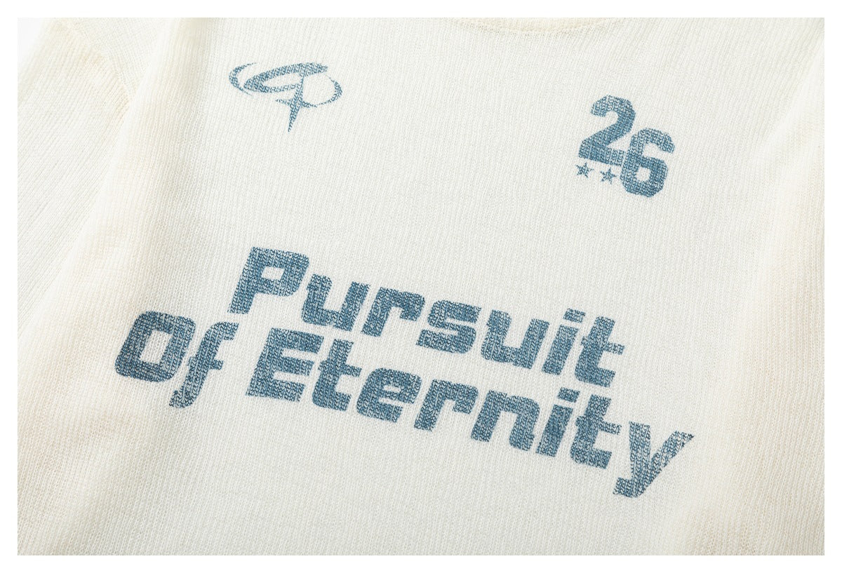 Close-up of blue English graphic lettering and number print on an ivory knit shirt.