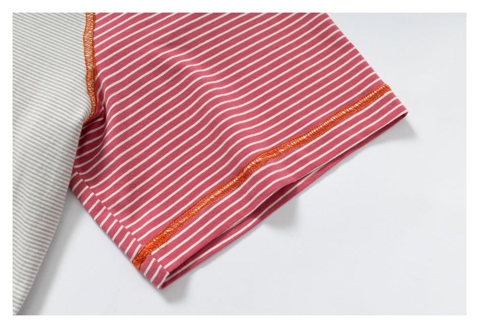 Close-up of the pink-and-white striped sleeve with orange overlock stitching at the cuff.