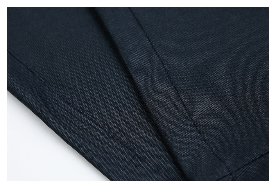Close-up of dark navy garment fabric with stitched seams and overlapping folds.