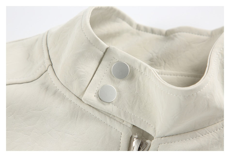 Close-up of an ivory jacket collar with two silver snaps and the top of its front zipper.