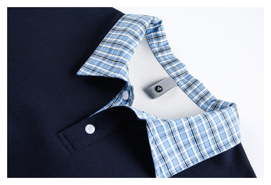 Close-up of a navy polo's blue plaid collar, white buttons, and inner neck label.