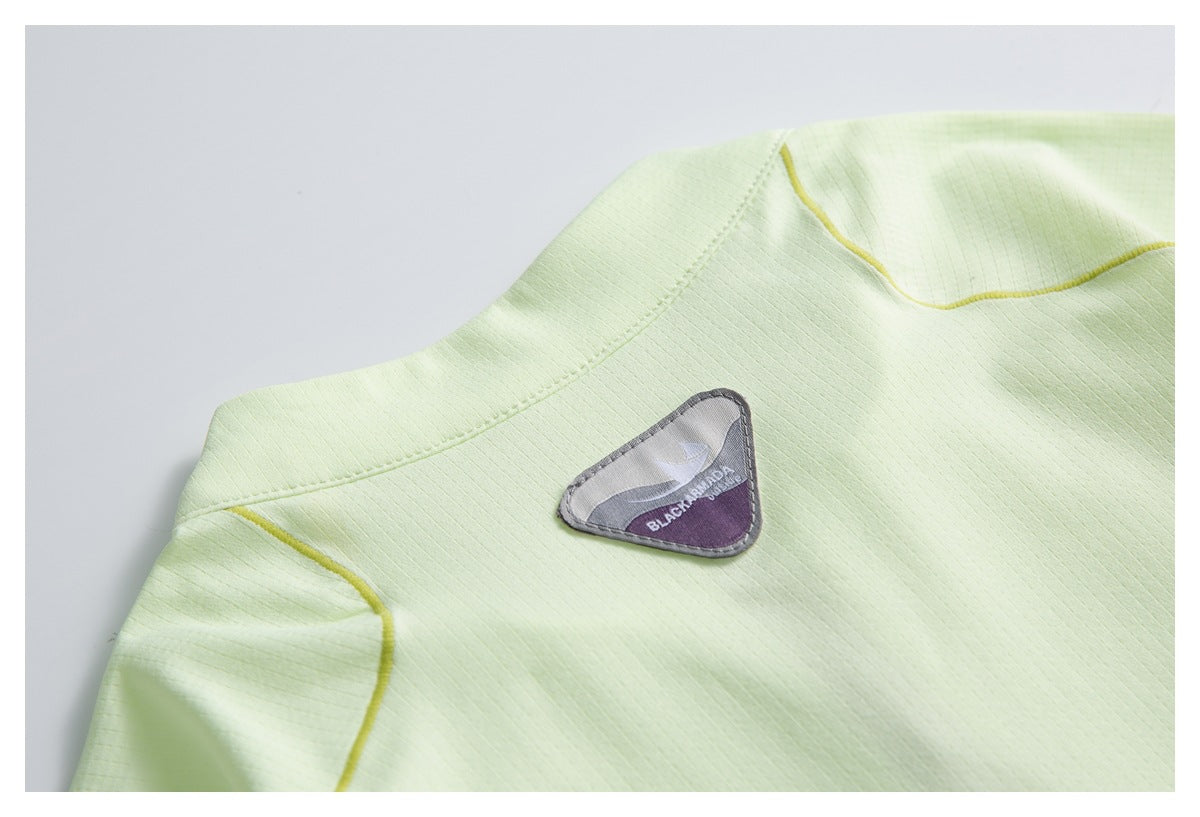 Close-up of a pale lime top's upper back with a triangular Black Yak patch and yellow piping.