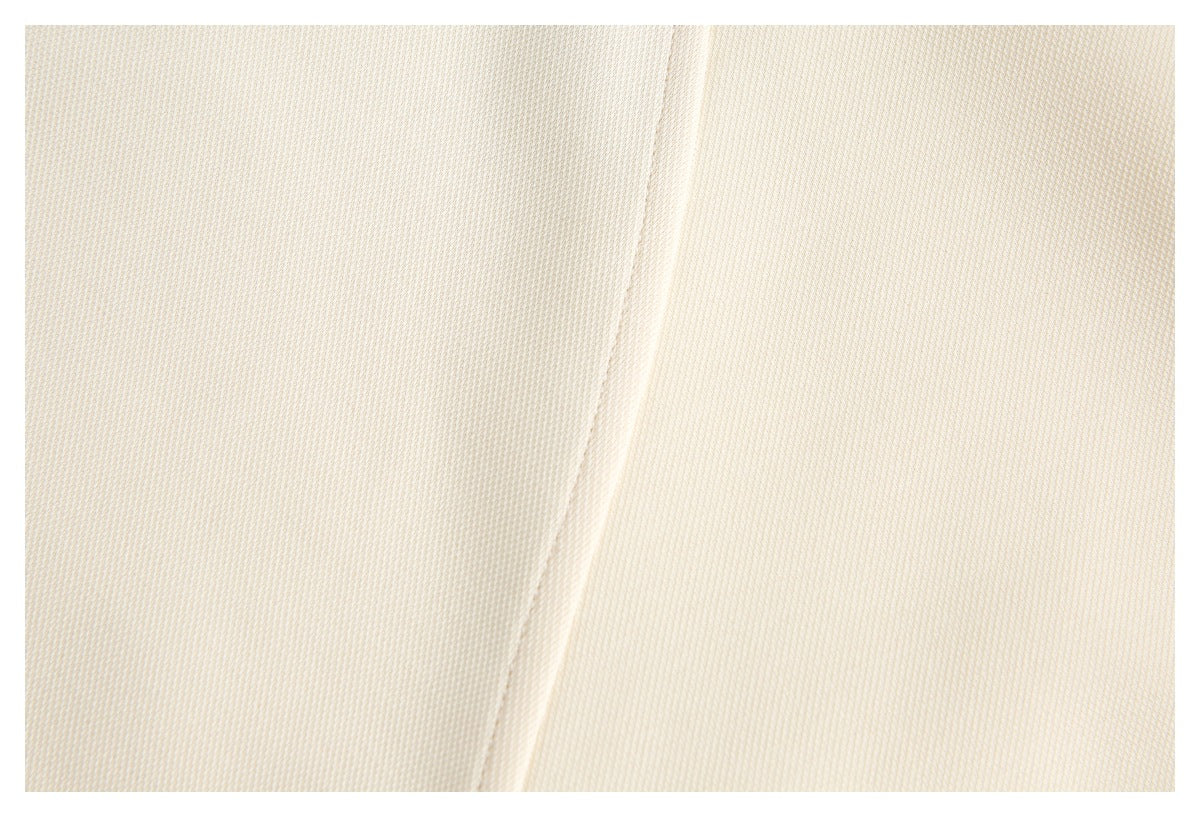 Close-up of cream fabric with a fine textured weave and a raised vertical seam or fold.
