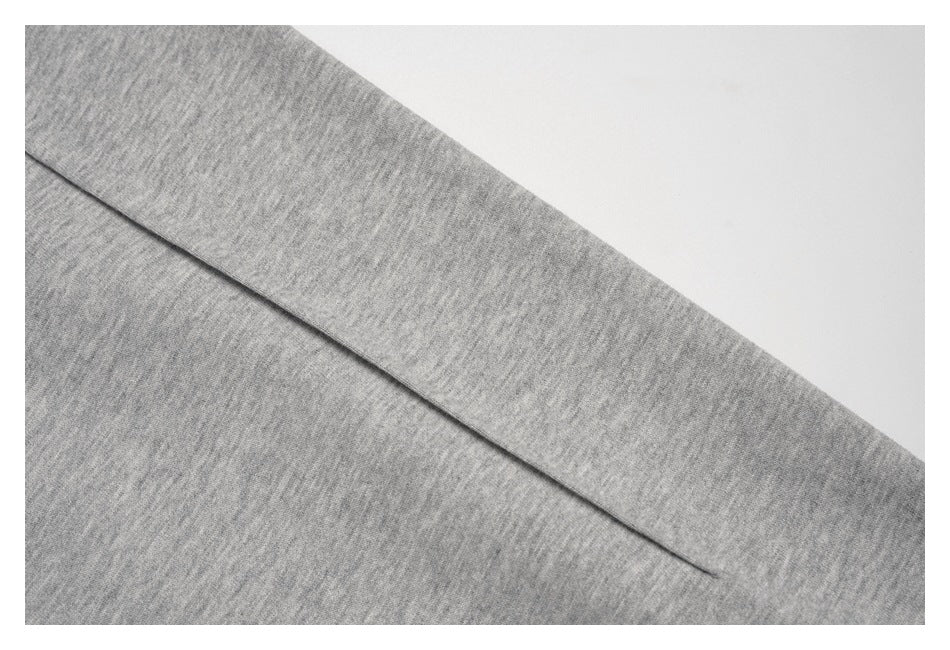 Close-up of a diagonal seam on heather-gray knit fabric.
