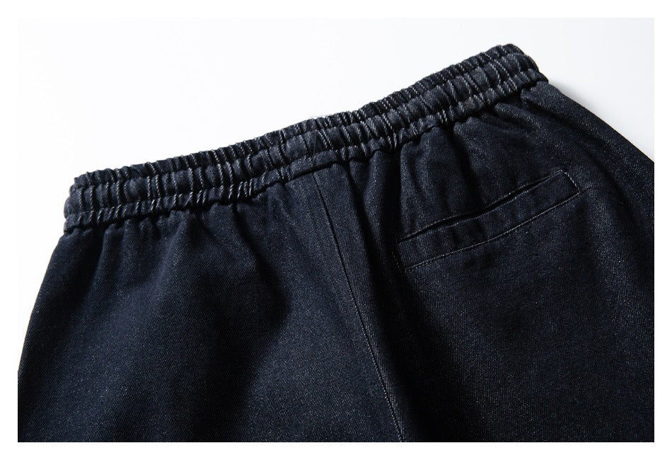 Close-up of dark indigo pants with an elastic waistband and a small back pocket.