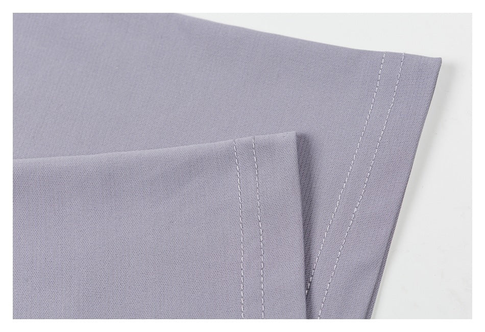 Close-up of a lavender-gray garment edge with parallel rows of stitching.