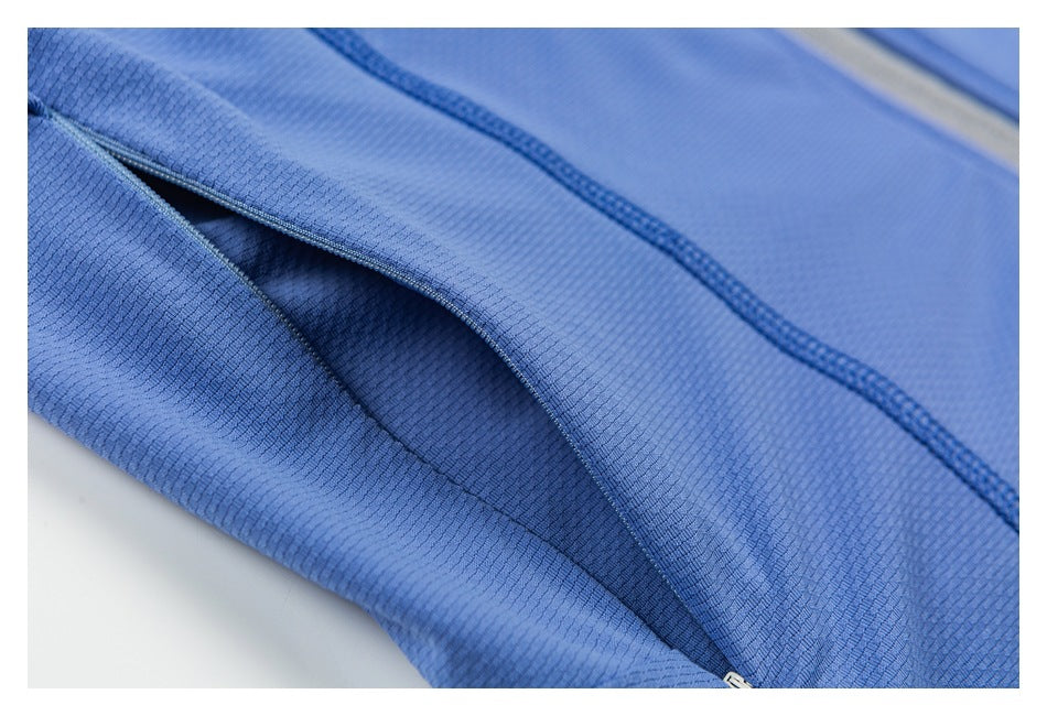 Close-up of a narrow opening between blue garment panels, with stitching and a zipper edge.