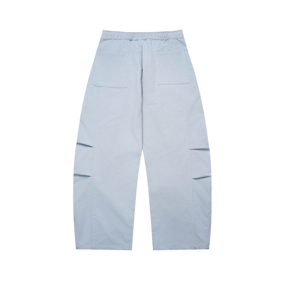 Full view of pale blue wide-leg trousers from the back, with two patch pockets and folded details at the knees.