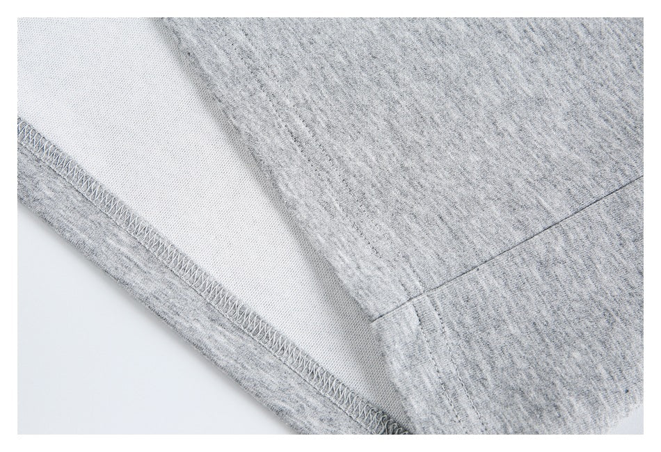 Inside close-up of a gray polo shirt hem showing overlock stitching and fabric.
