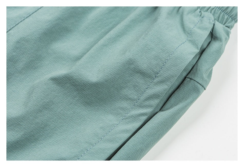 Close-up of mint-green shorts showing the fabric and a stitched side seam.