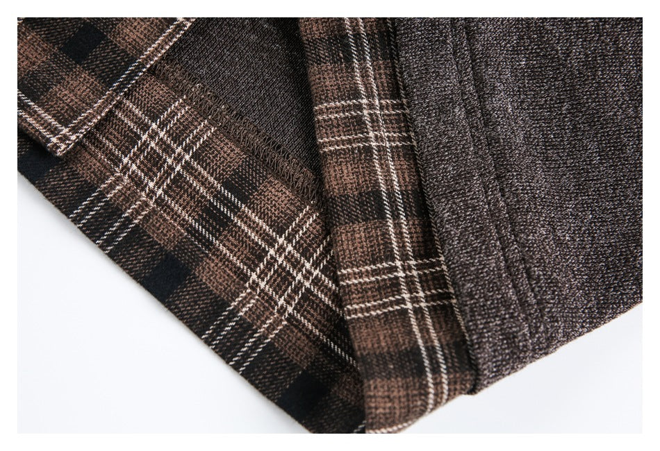Close-up of brown and black plaid fabric next to the dark brown jacket's textured edge.