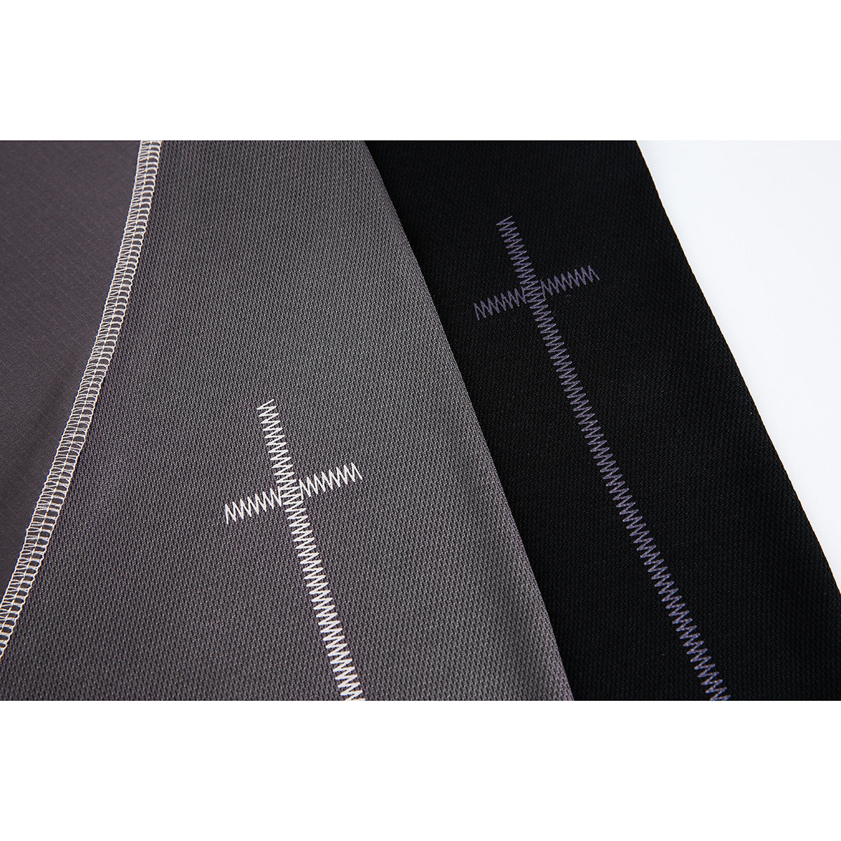 Close-up of gray and black T-shirt panels with contrasting zigzag stitching and visible seam details.