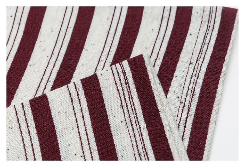 Close-up of the striped shirt fabric and folded sleeve edge, showing burgundy and cream bands.