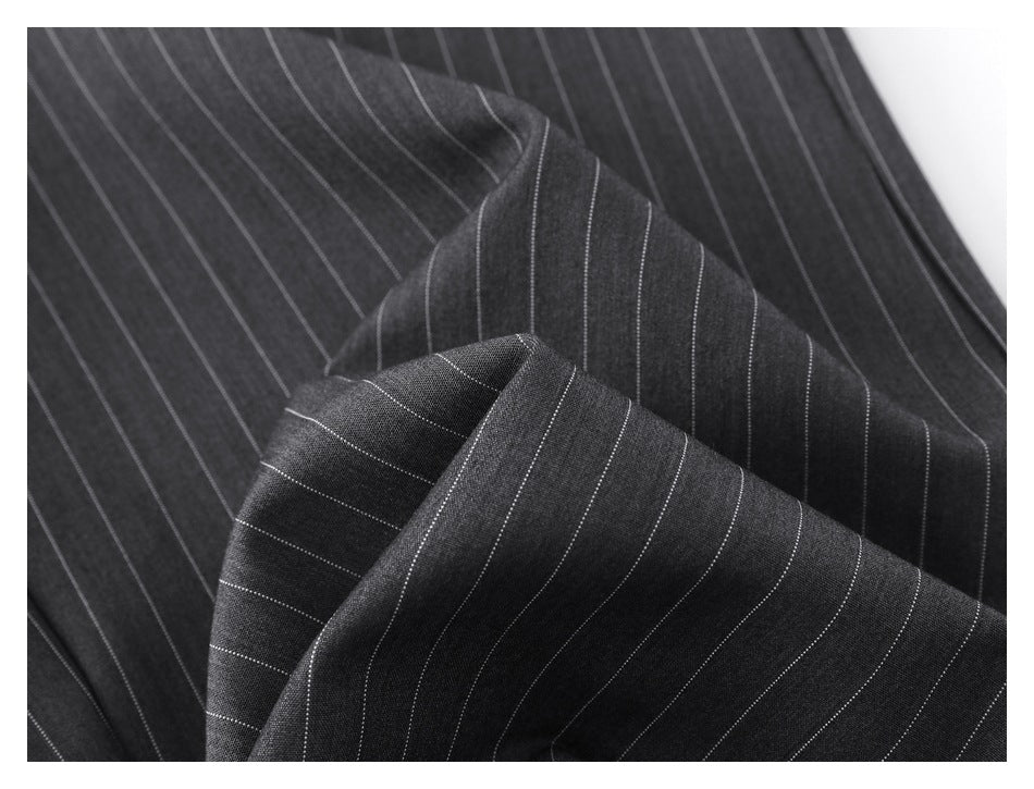Close-up of charcoal pinstripe trouser fabric folded to show the fine stripe pattern.