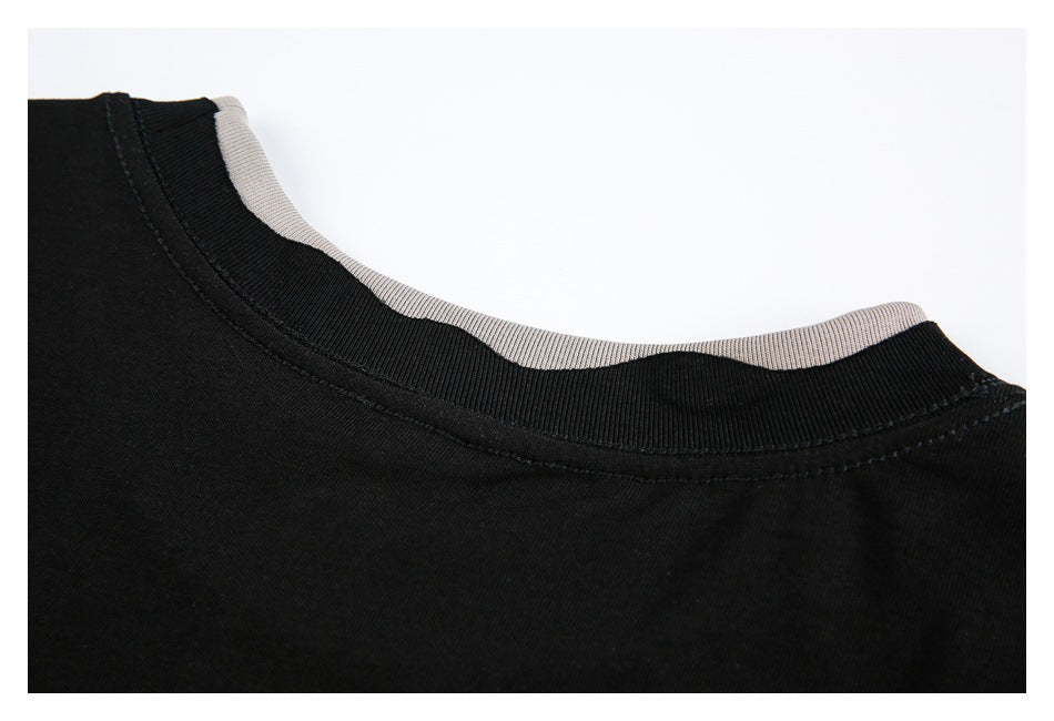 Close-up of a black crew neckline with ribbed trim and a light-colored inner layer.