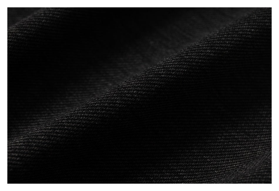 Macro view of the black fabric's fine diagonal knit texture.