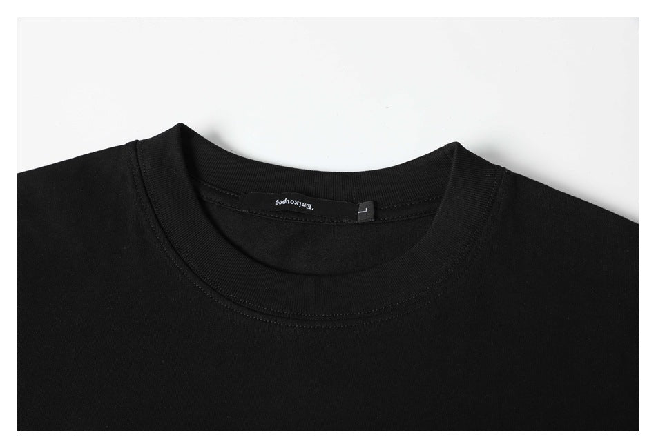 Close-up of a black T-shirt's ribbed crew neck, stitching, shoulders, and inner neck label.