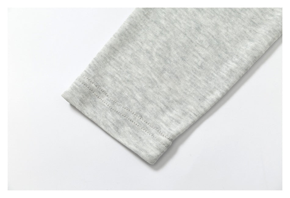 Close-up of a stitched sleeve cuff on heather-gray fabric.