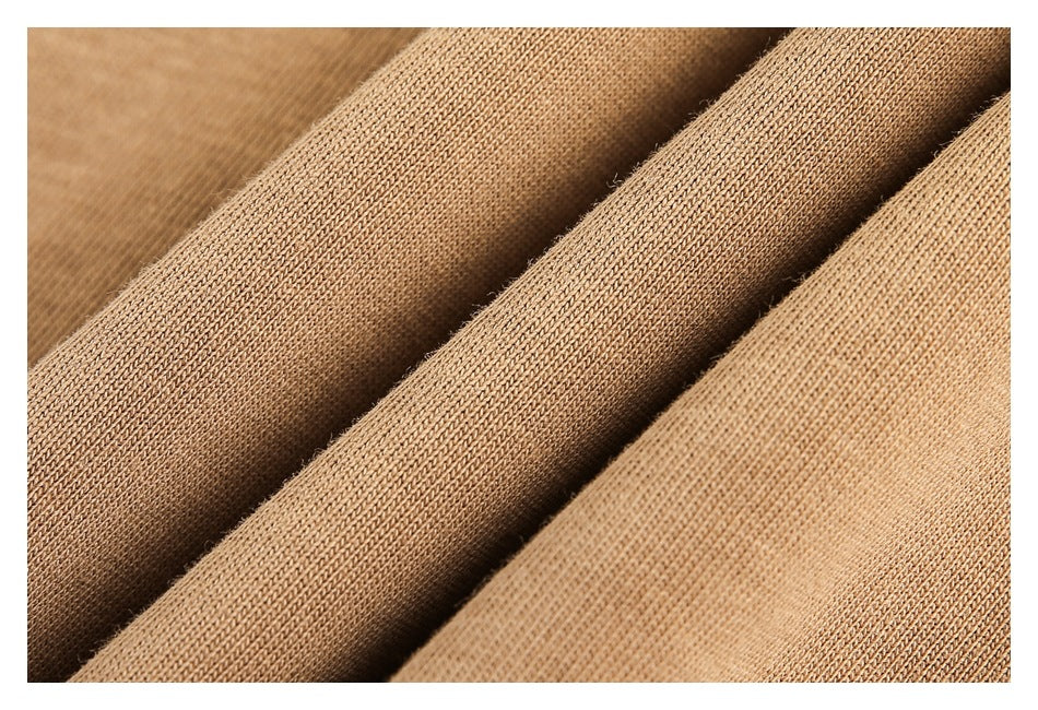 Macro view of tan knit fabric folded to show its surface texture.